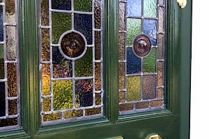 Green door with stained glass panels